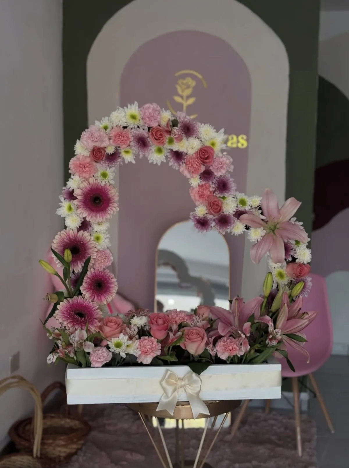 Arreglo en forma de corazón con gerberas, rosas y lilis sobre caja blanca